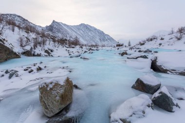Güneşli kış gününde, karlı dağlarda donmuş akıntı, Urallar  