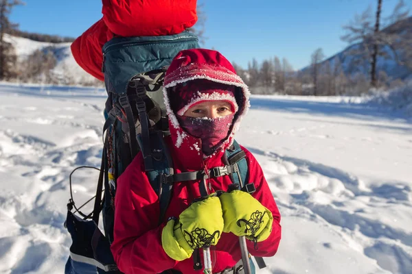 在阳光明媚的冬日穿着保暖运动服在雪山徒步旅行 — 图库照片