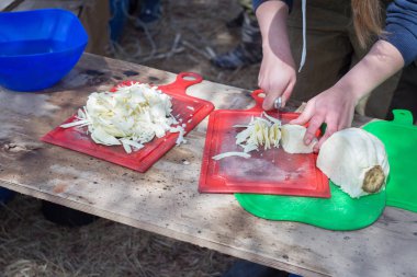 Yürüyüşte yemek pişirmek. Bir kız salata ya da çorba için lahana keser. 