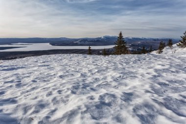 Dağlarda kış manzarası. Gökyüzünde bulutlar, güneşli bir gün. Bir sürü kar, buz, soğuk alan. Ural Dağları, Rusya.