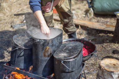 Kazıkta çorba hazırlığı. Bir kadın yemek hazırlıyor.