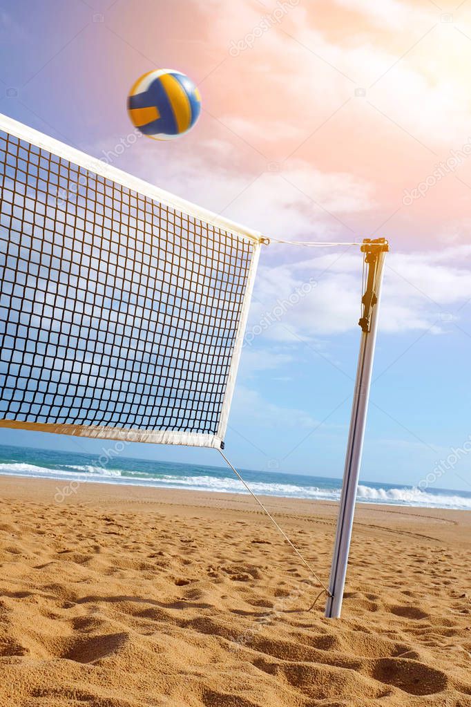Bright beach scene with net and volley ball at sunset