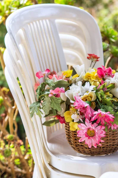 Cesta Flores Uma Pilha Cadeiras Plástico Branco — Fotografia de Stock