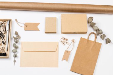 Beyaz bir masada zarf, çanta, etiket, kağıt ve diğer şeyler