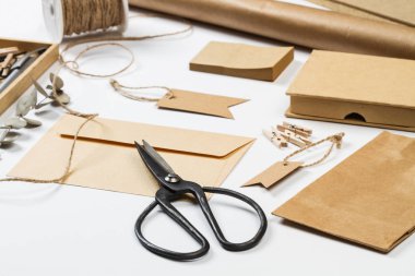 Beyaz bir masada zarf, çanta, etiket, kağıt ve diğer şeyler