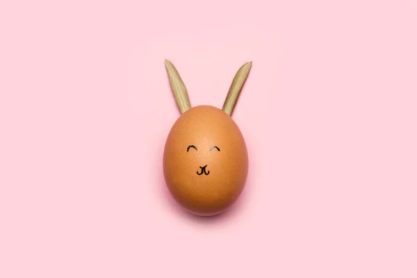 Яйцо Лицом Кроличьими Ушами Розовом Фоне — стоковое фото