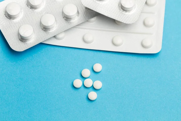 Açık mavi arka planda tıbbi haplar
