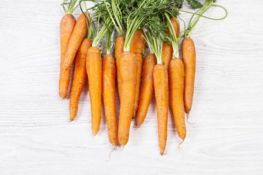 Ahşap bir masada yaprakları ile Çiğ havuç