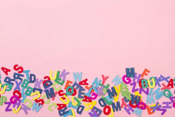 粉红色背景上的彩色塑料字母 — 图库照片