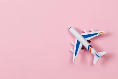 Pembe arka plan üzerinde bir oyuncak uçak