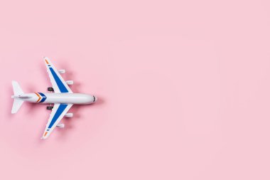 Pembe arka plan üzerinde bir oyuncak uçak