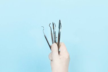 Tıbbi eldivenile diş hekimi elinde diş aletleri