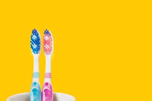 Plastic Colored Toothbrushes Ceramic Glass Yellow Background — Stock Photo, Image