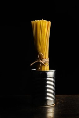 Karanlık bir arka planda bir teneke olabilir bağlı çiğ noodle