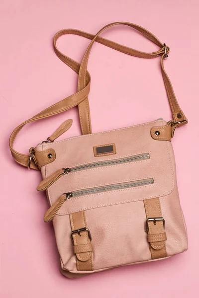 A leather woman handbag on a pink background