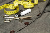 Nůžky, patrony a jiné nástroje pro přizpůsobení na šedém obleku