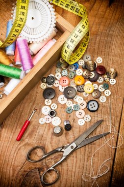 Ahşap bir kutuda dikiş ipliği ve dikiş aksesuarları