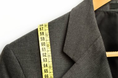 Gri takım elbise üzerinde sarı ölçüm bandı