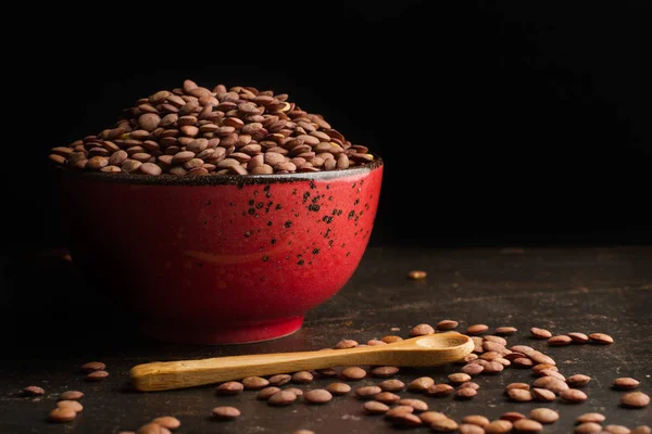 暗い背景に赤いボウルのレンズ豆 — ストック写真
