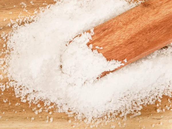 Salt in flakes on a wooden spoon