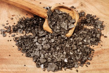 Tahta bir kaşık üzerinde pul siyah tuz