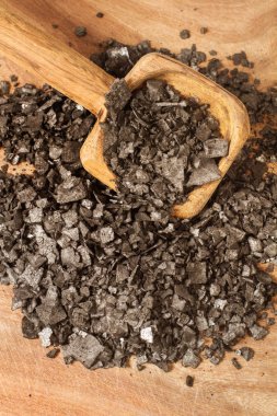 Tahta bir kaşık üzerinde pul siyah tuz