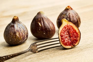 Tahta bir masada çatal ile üç buçuk incir