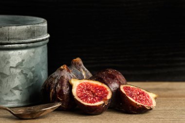 Ahşap bir masa üzerinde bir konserve ile üç buçuk incir