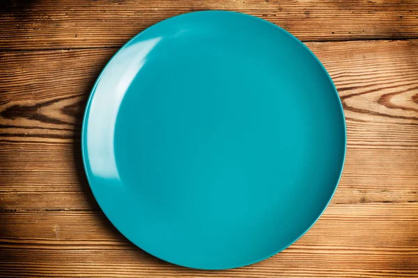 Ένα Μπλε Πιάτο Ένα Ξύλινο Τραπέζι — Φωτογραφία Αρχείου
