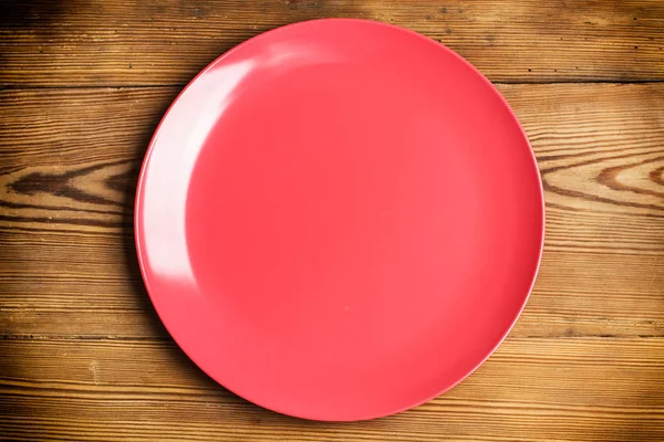 Ένα Κόκκινο Πιάτο Ένα Ξύλινο Τραπέζι — Φωτογραφία Αρχείου