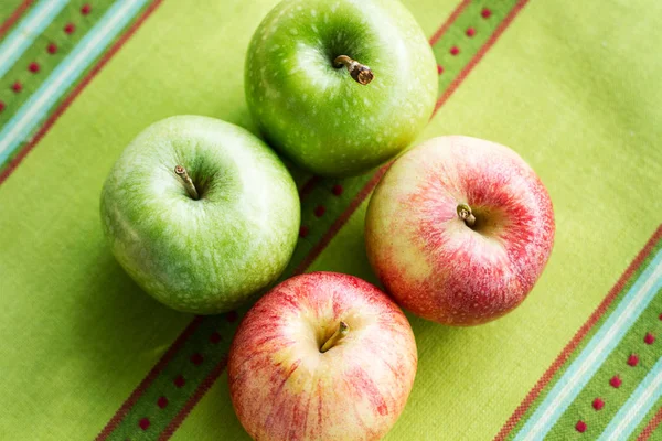 Green and red apples on a green napkin