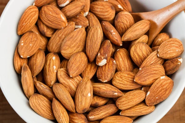 Almendras Peladas Tazón Con Una Cuchara Madera —  Fotos de Stock