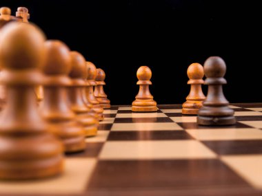 Karanlık bir arka plan üzerinde tahta ve satranç taşları