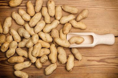 Tahta kaşıkla ve tahta bir masa üzerinde yer fıstığı