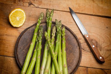 Ahşap bir masada yeşil kuşkonmaz