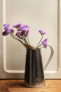 Ahşap bir masa üzerinde bir kavanozda menekşe çiçekleri