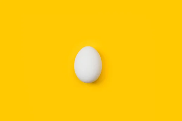 Białe Jajko Żółtym Tle — Zdjęcie stockowe