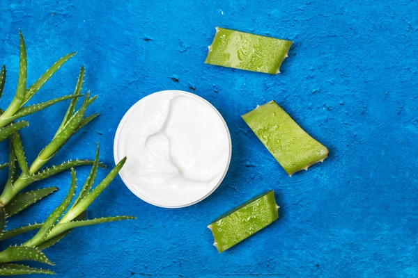 Pedaços Folha Aloe Vera Com Pote Creme Hidratante Fundo Azul — Fotografia de Stock