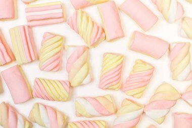 Pembe ve sarı şekerlemeler beyaz arkaplanda izole edilmiş.