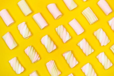 Sarı arkaplanda sarı ve pembe şekerlemeler.