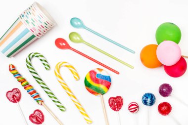 Beyaz arka planda çeşitli lolipoplar ve baston şekerler.