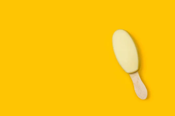 Biała Czekolada Zanurzony Lolly Lodu Żółtym Tle — Zdjęcie stockowe