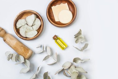 Okaliptüs, ahşap bir kasede ve arka planda dallar bırakır.