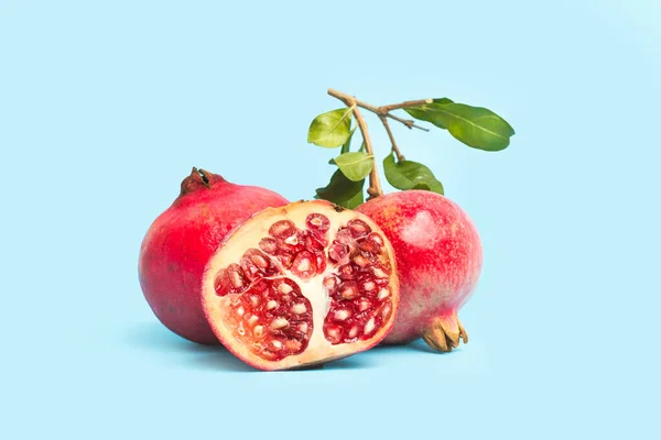 Granaatappels Met Takken Bladeren Een Lichtblauwe Ondergrond — Stockfoto