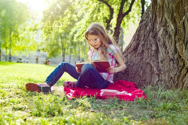 Девочка Очках Читает Книгу Парке Траве Возле Дерева — стоковое фото