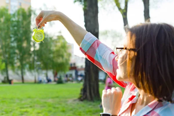 Mujer Madura Sosteniendo Despertador Mano Mirando Hora Fondo Soleado Parque —  Fotos de Stock