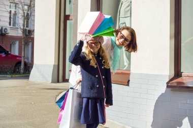 Kadın ve küçük kızı ile alışveriş torbaları street yürüyüş.