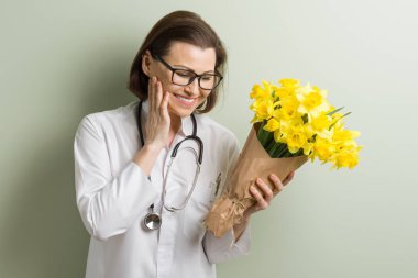 Buket çiçek ile gülümseyen kadın doktor. Dünya Sağlık günü, doktorlar gün