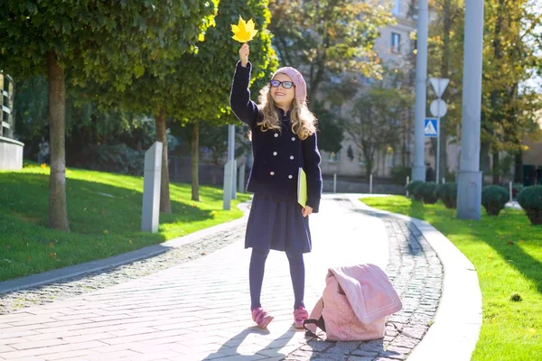 Sokak portre sevimli bir kız gözlük, ceket, Fransız bere elinde bir defter ile sonbahar şehir arka plan.