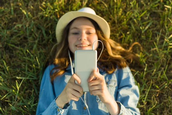 Chica Adolescente Sombrero Con Auriculares Encuentra Hierba Verde Mira Teléfono — Foto de Stock